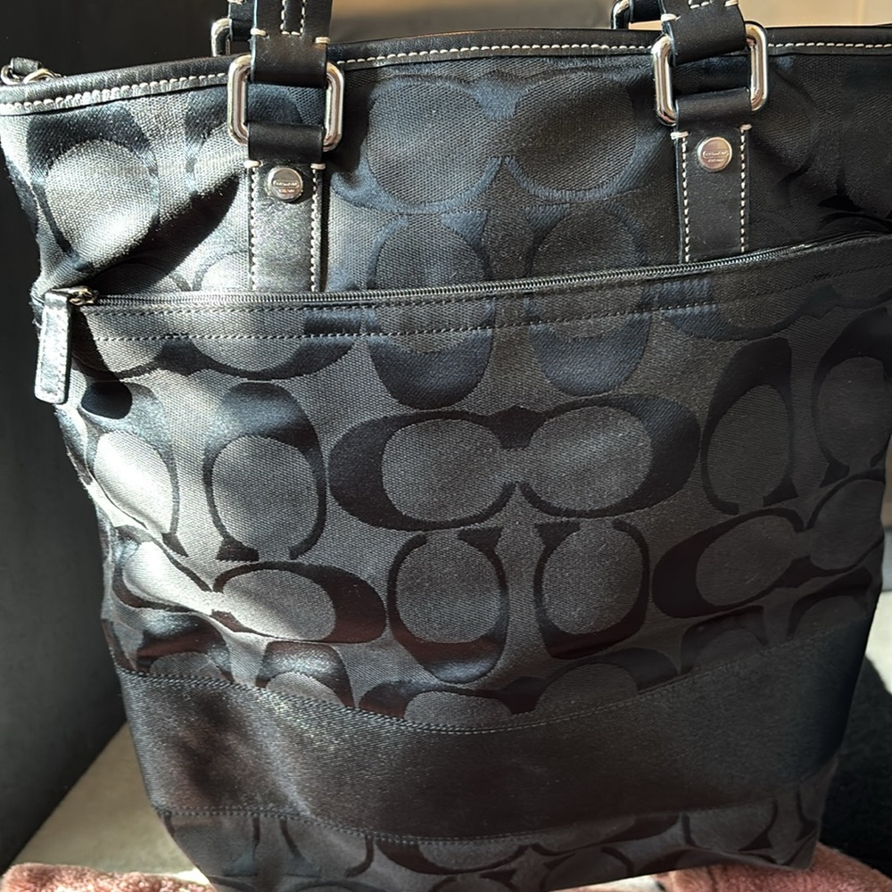 Coach bag with leather straps in black with stripe detail.
